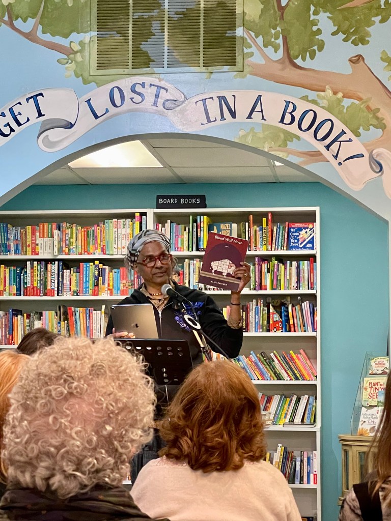 Ignatius hosting Sunday Salon Chicago, and holding up an author's book.